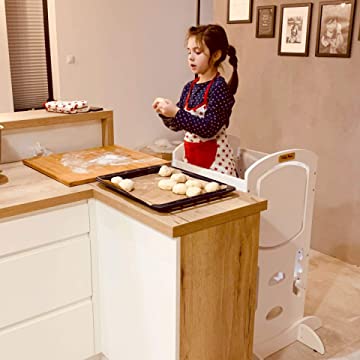 petite fille sur une tour faisant la cuisine