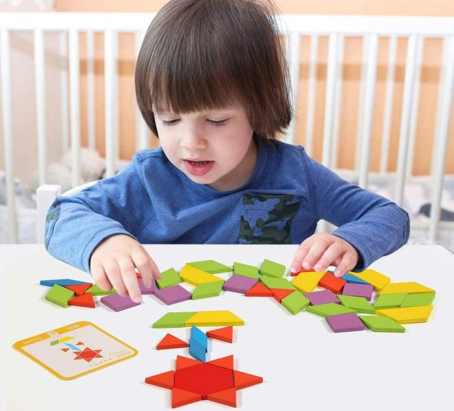 Un jeune garçon jouant au tangram Montessori avec concentration
