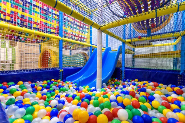 Terrain de jeu pour enfants à l'intérieur. Un exemple de parcours de motricité. Vue panoramique de l'intérieur de la piscine sèche avec des balles colorées et un toboggan.