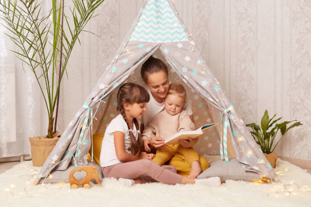 istockphoto-1412913599-612x612-1 Une maman qui fait la lecture pour ses 2 filles dans un lit tipi Montessori