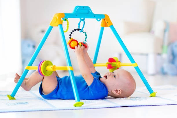 istockphoto-649872012-612x612-1 Un bébé sur un tapis de motricité équipé d'un jouet suspendu