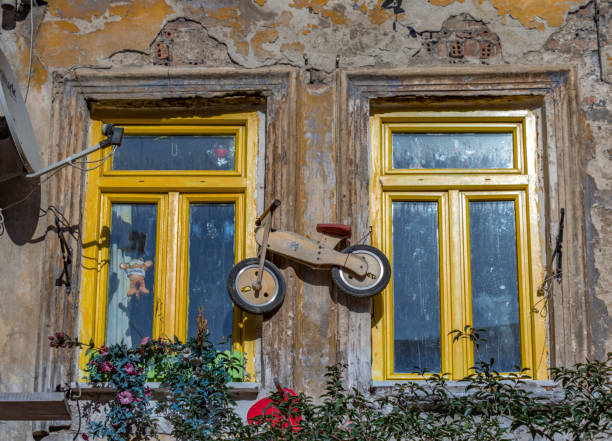 Fenêtres à cadre jaune et draisienne en bois.
