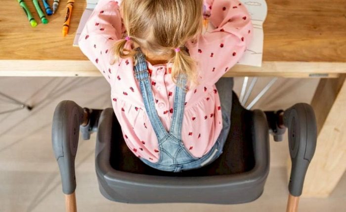 Un enfant assise sur une chaise haute évolutive