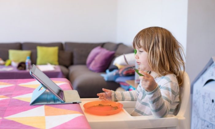 Un enfant assise sur une chaise haute évolutive