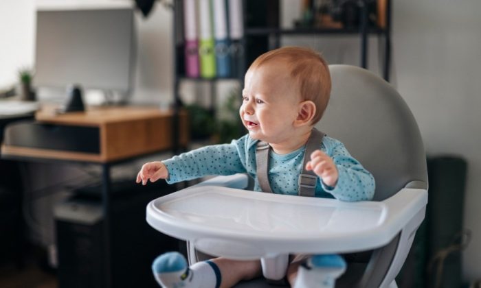 Un enfant assise sur une Chaise haute évolutive