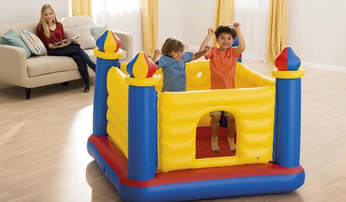 Une mère qui regarde ses enfants jouant sur un château gonflable