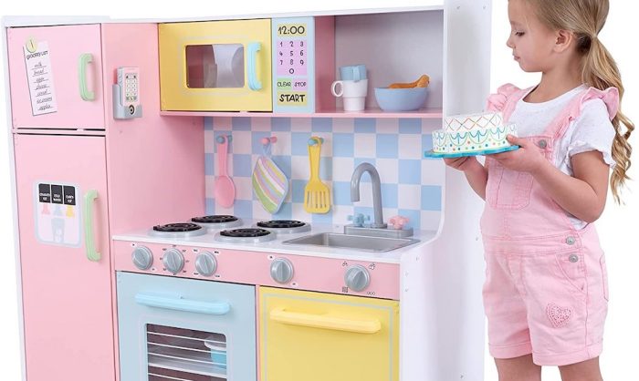 Un enfant tenant un gâteau dans la cuisine