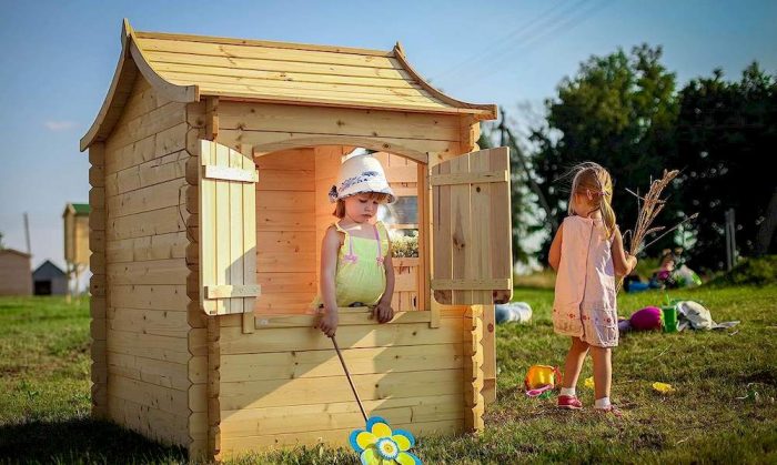 Un enfant à l'intérieur et une autre à l'extérieur d'une maisonnette en bois