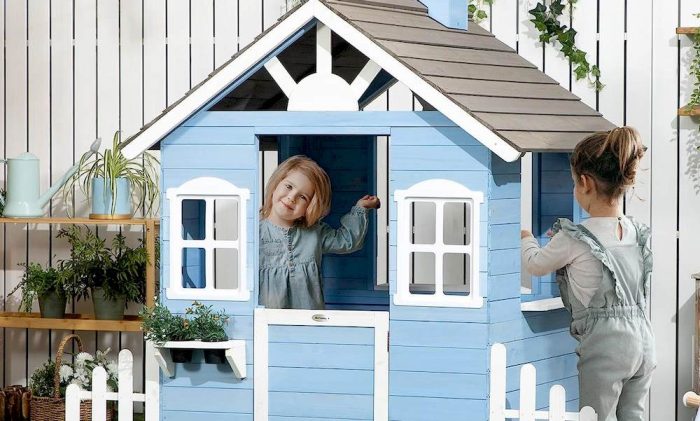 Un enfant à l'intérieur et une autre à l'extérieur d'une maisonnette en bois