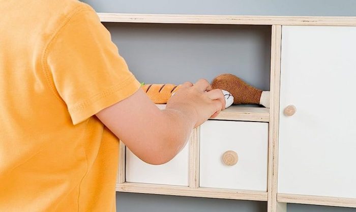 Un enfant jouant avec une marchande en bois