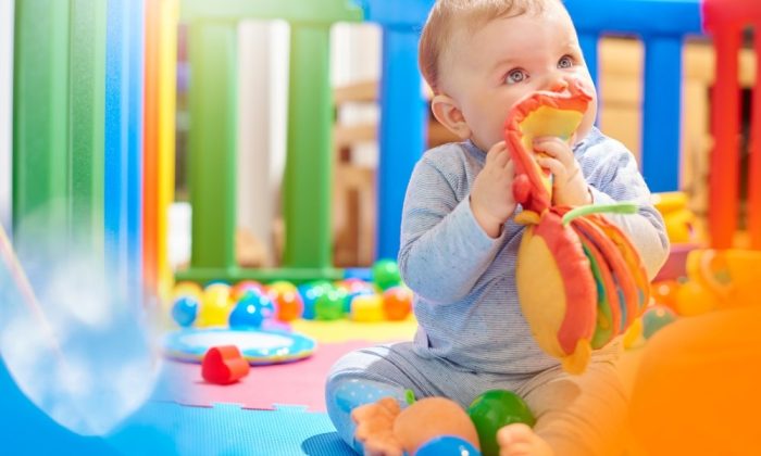 Un bébé dans un parc avec de nombreux jouets