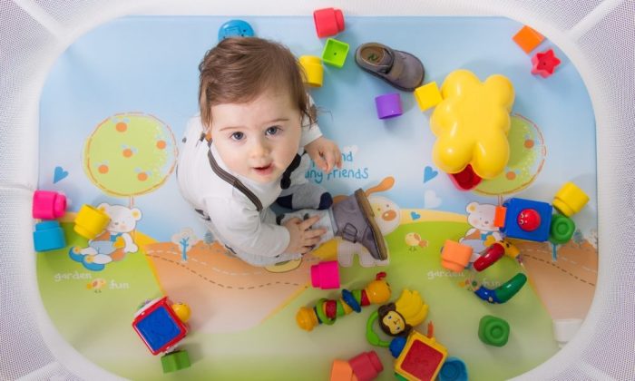 Un bébé dans un parc avec de nombreux jouets