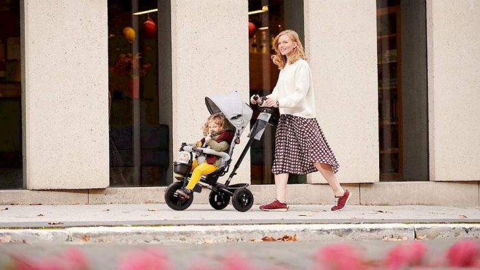 Une mère poussant son enfant sur le tricycle Kinderkraft