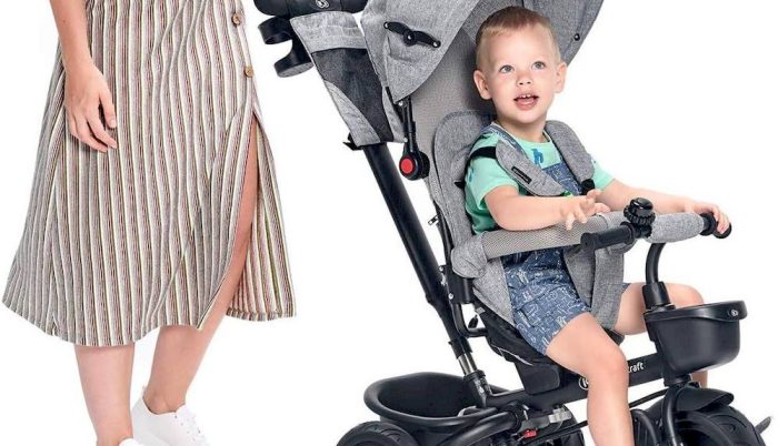 Mère avec son enfant assise sur un tricycle Kinderkraft