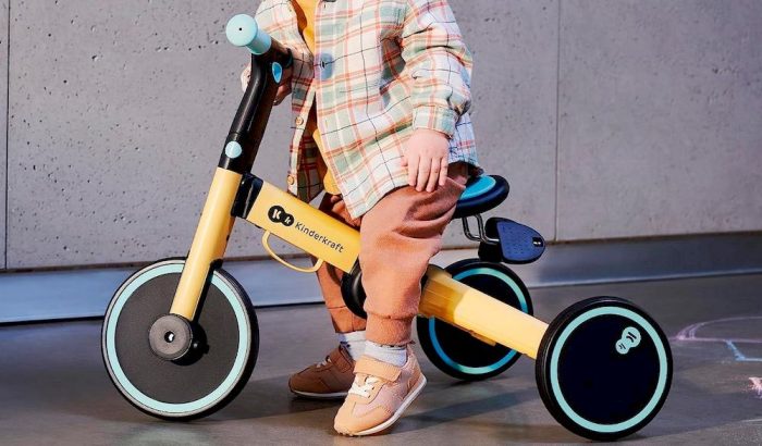Un enfant assise sur un tricycle Kinderkraft
