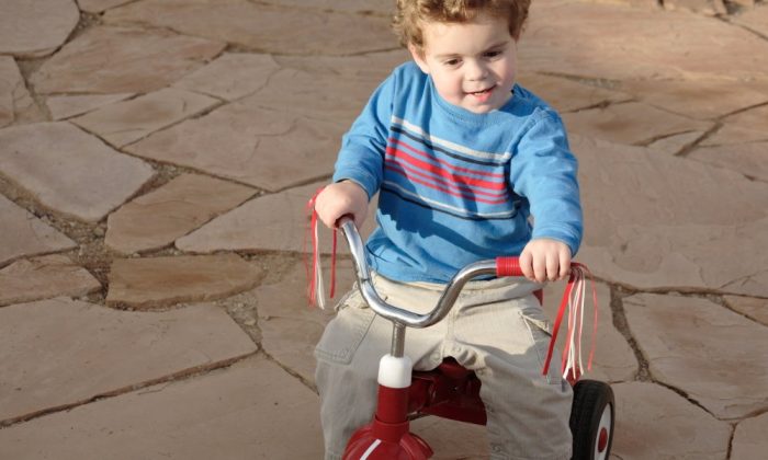 Un enfant jouant avec un tricycle évolutif