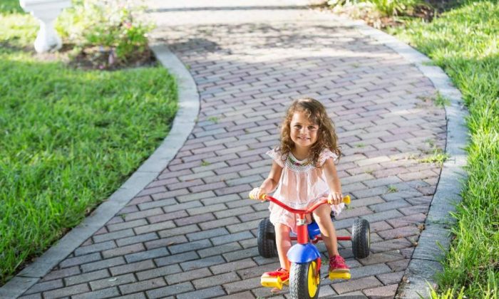 Une fille jouant avec un tricycle évolutif