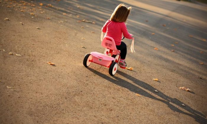 Une fille jouant avec un tricycle évolutif