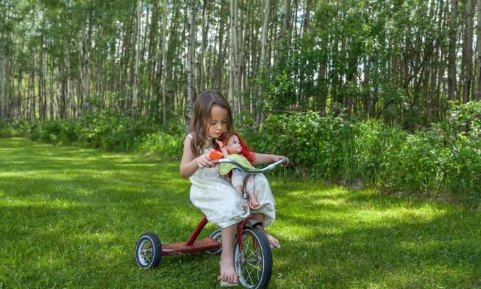 Une fille jouant avec un tricycle évolutif