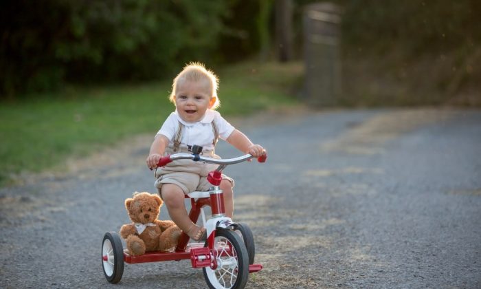Un enfant assise sur un tricycle évolutif