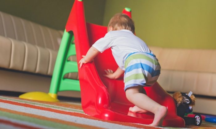 Un bébé grimpant sur un toboggan